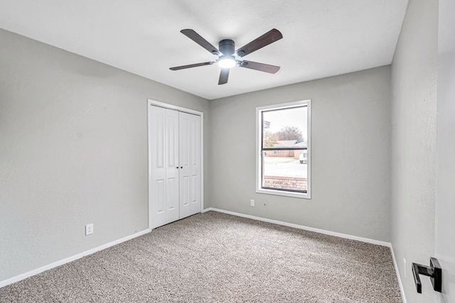 unfurnished bedroom featuring a closet, carpet flooring, ceiling fan, and baseboards