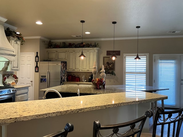 kitchen with a breakfast bar, backsplash, ornamental molding, decorative light fixtures, and stainless steel fridge with ice dispenser