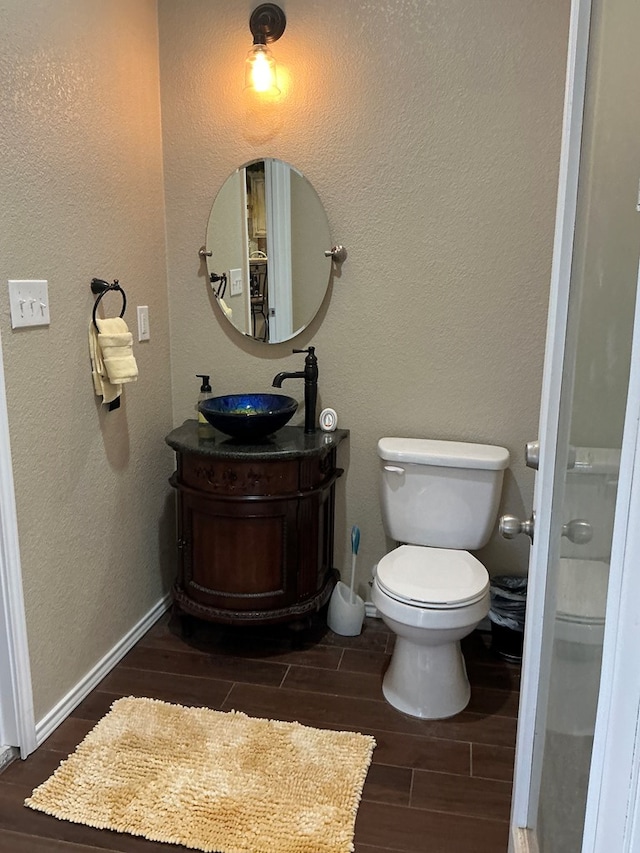 bathroom with hardwood / wood-style floors, vanity, and toilet