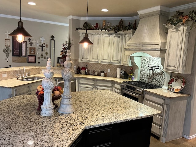 kitchen with light stone countertops, sink, stainless steel appliances, premium range hood, and decorative light fixtures