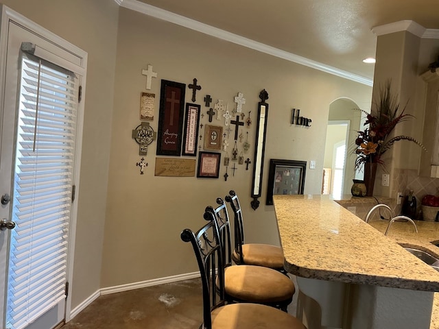 dining space featuring sink, plenty of natural light, and ornamental molding