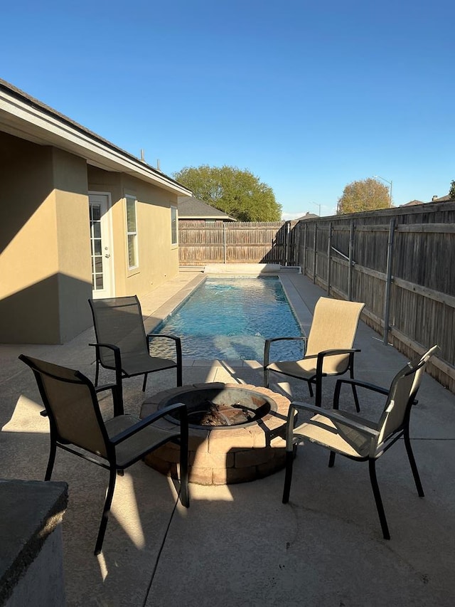 view of swimming pool featuring an outdoor fire pit and a patio area