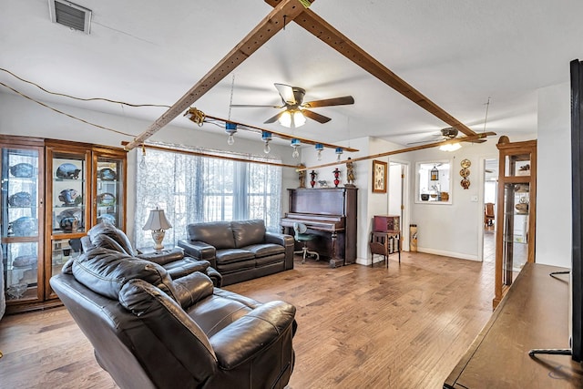 living room featuring ceiling fan, beam ceiling, and light wood-type flooring