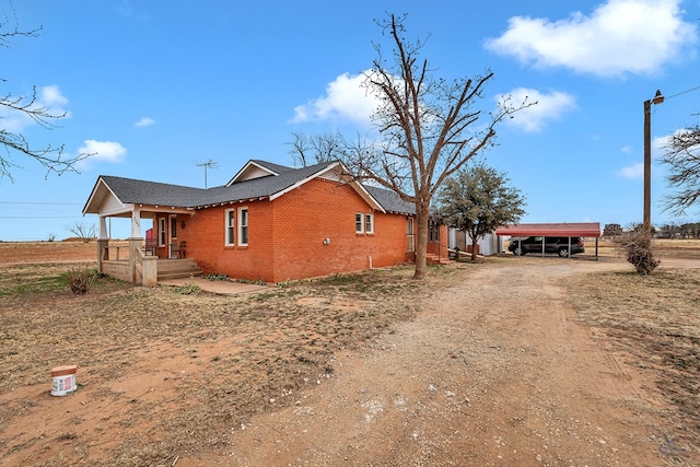 view of side of property with a carport and a porch