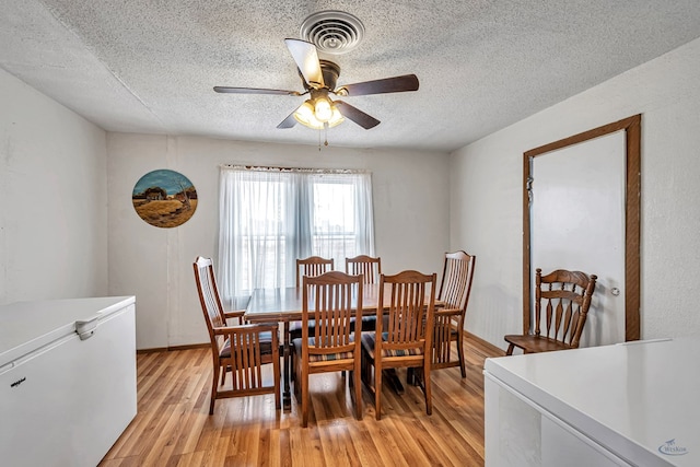 dining area featuring ceiling fan, a textured ceiling, and light hardwood / wood-style floors