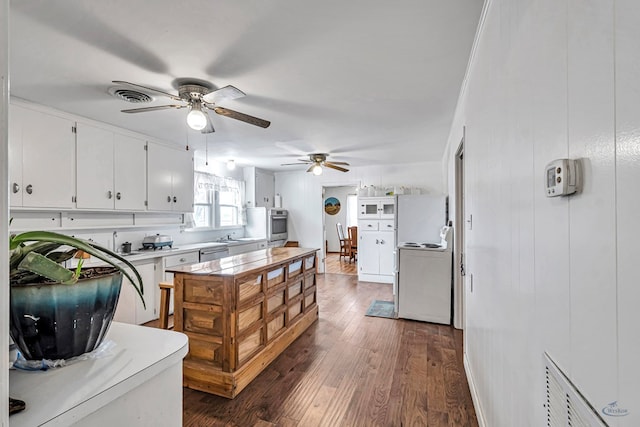 kitchen featuring white cabinetry, stainless steel appliances, dark hardwood / wood-style floors, and ceiling fan