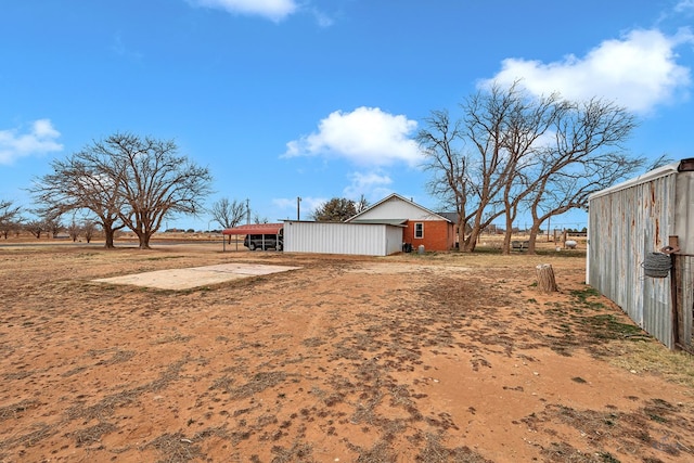 view of yard with a rural view and a carport