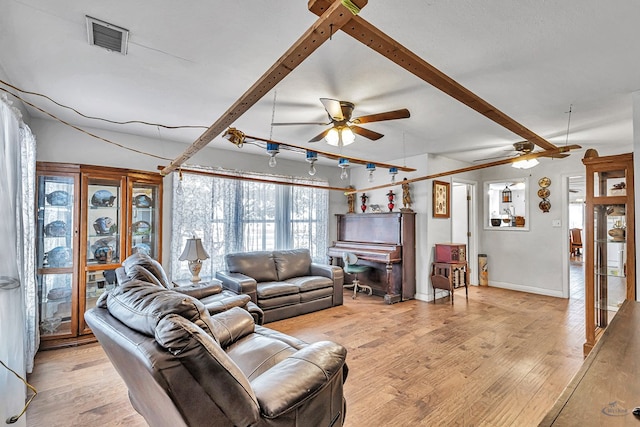 living room featuring beamed ceiling, ceiling fan, and light hardwood / wood-style flooring