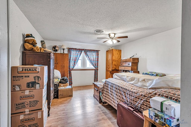 bedroom featuring ceiling fan, wood-type flooring, and a textured ceiling