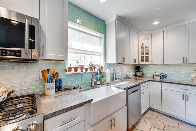 kitchen featuring decorative backsplash, white cabinetry, and appliances with stainless steel finishes