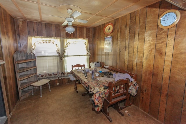 dining room with ceiling fan, carpet, and wooden walls