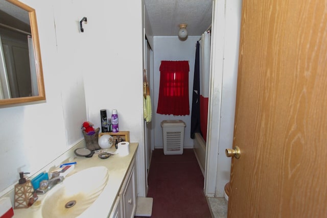 bathroom with a textured ceiling and vanity