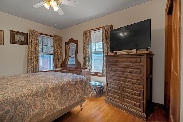 bedroom featuring ceiling fan, ornamental molding, and light wood-type flooring