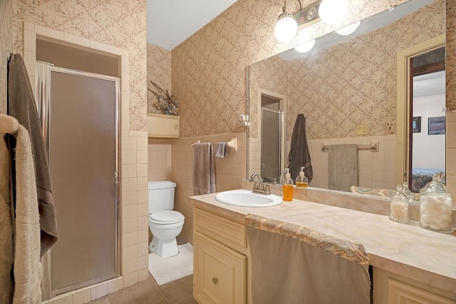 bathroom featuring vanity, toilet, tile patterned floors, wallpapered walls, and a stall shower