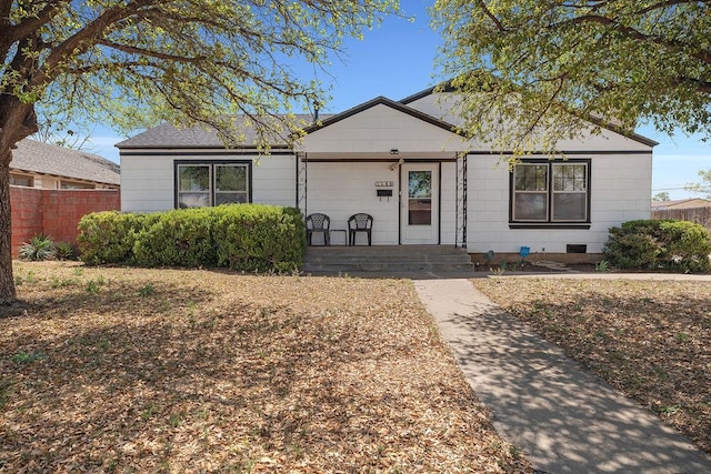 view of front facade featuring fence and covered porch