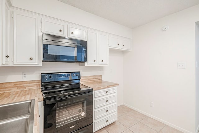 kitchen with black appliances, white cabinets, and a sink