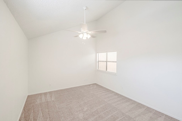 spare room with lofted ceiling, a textured ceiling, light carpet, and baseboards