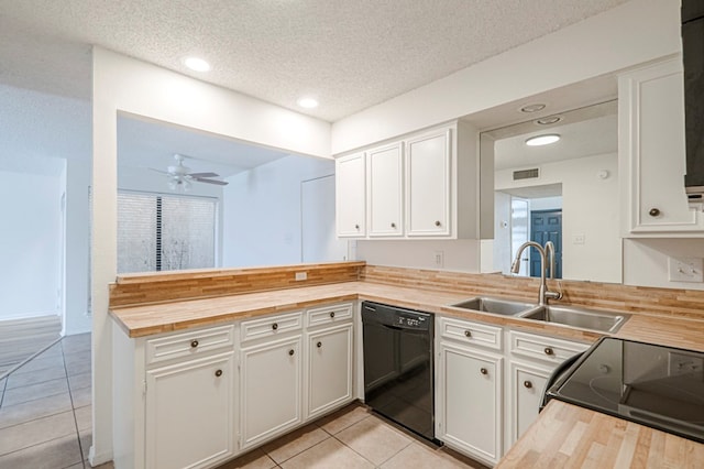 kitchen with butcher block counters, white cabinets, dishwasher, and a sink