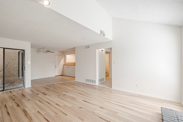 unfurnished living room with light wood-type flooring, ceiling fan, visible vents, and a textured ceiling