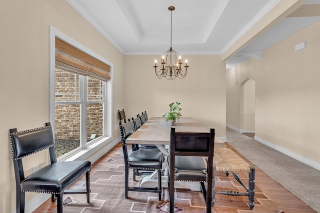 131 High Lonesome Dr, Alpine, TX 79830 - carpeted dining space featuring arched walkways, a tray ceiling, a chandelier, baseboards, and crown molding