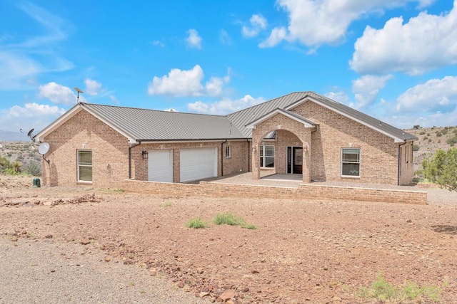 131 High Lonesome Dr, Alpine, TX 79830 - ranch-style house with brick siding, a garage, metal roof, and a standing seam roof