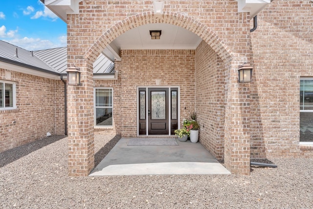 131 High Lonesome Dr, Alpine, TX 79830 - view of exterior entry featuring brick siding and a patio