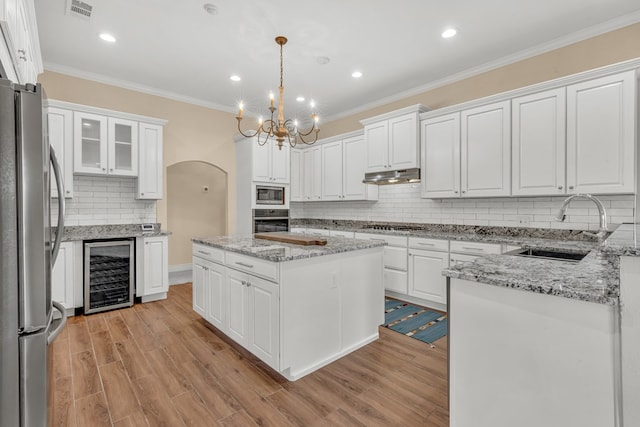 131 High Lonesome Dr, Alpine, TX 79830 - kitchen featuring wine cooler, stainless steel appliances, a sink, under cabinet range hood, and decorative backsplash