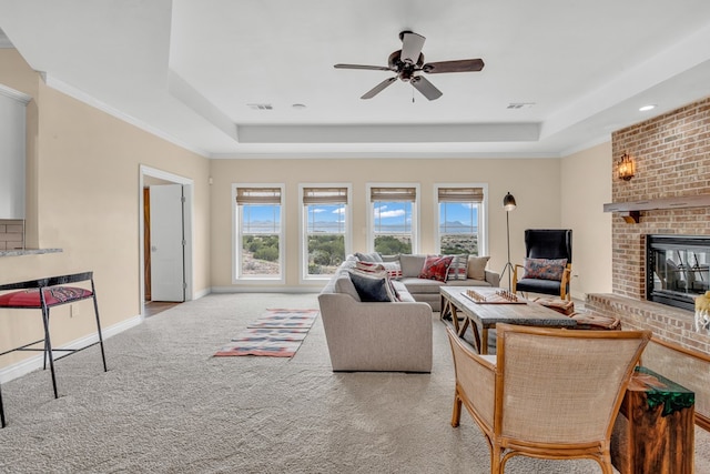 131 High Lonesome Dr, Alpine, TX 79830 - carpeted living area featuring a raised ceiling, a brick fireplace, a ceiling fan, and baseboards