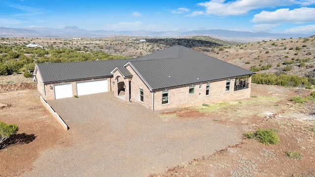 131 High Lonesome Dr, Alpine, TX 79830 - view of front of property with driveway, metal roof, an attached garage, and a mountain view