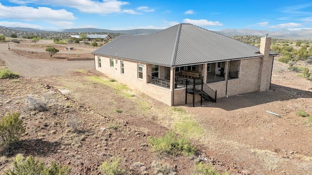 131 High Lonesome Dr, Alpine, TX 79830 - view of home's exterior featuring a chimney, metal roof, and a mountain view