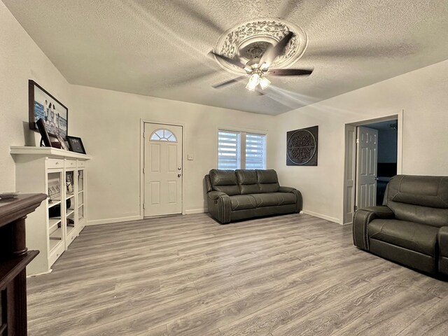 living room with ceiling fan, hardwood / wood-style floors, and a textured ceiling