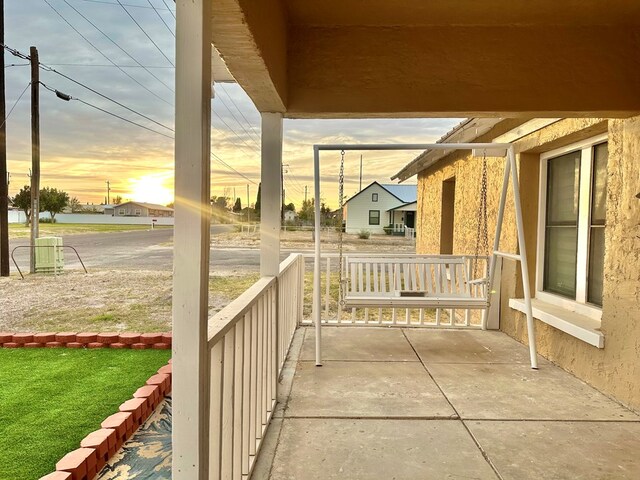 patio terrace at dusk featuring a porch