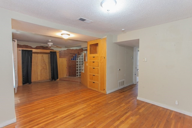 empty room featuring hardwood / wood-style flooring, ceiling fan, and a textured ceiling