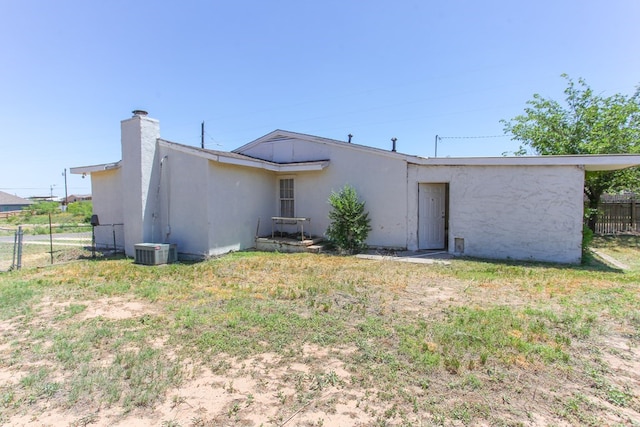 back of house with a lawn and central air condition unit