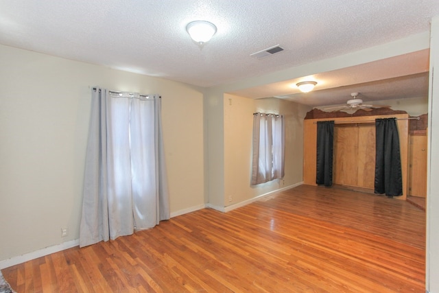 spare room with a textured ceiling, hardwood / wood-style flooring, and ceiling fan