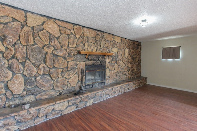 unfurnished living room with dark hardwood / wood-style flooring, a textured ceiling, and a fireplace