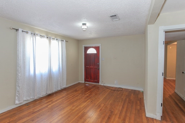 entrance foyer featuring dark hardwood / wood-style floors and a textured ceiling