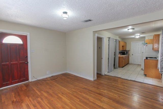 foyer featuring light hardwood / wood-style floors and a textured ceiling