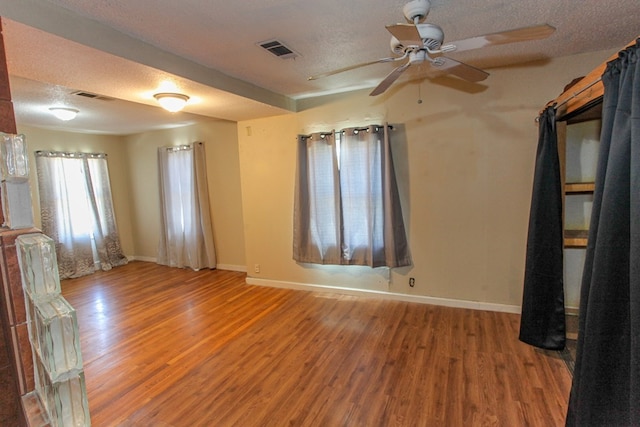 unfurnished room featuring hardwood / wood-style flooring and a textured ceiling