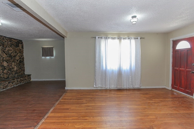 foyer entrance featuring hardwood / wood-style flooring and a textured ceiling