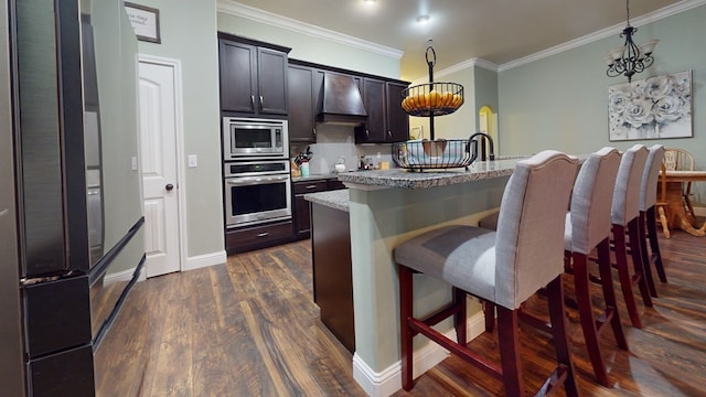 kitchen with stainless steel appliances, decorative light fixtures, premium range hood, and a kitchen bar