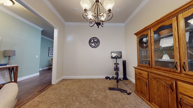 exercise area featuring a notable chandelier, baseboards, dark colored carpet, and crown molding