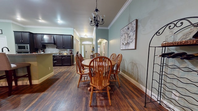 dining area featuring arched walkways, ornamental molding, dark wood-style floors, and baseboards