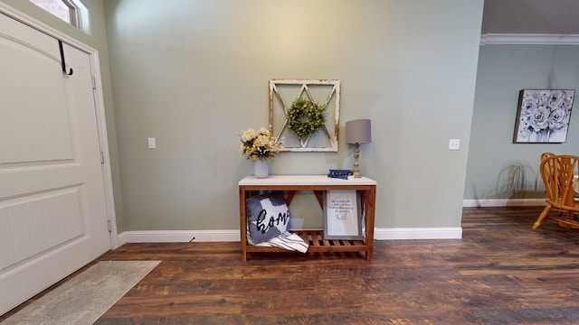 entrance foyer featuring dark wood-style flooring, crown molding, and baseboards