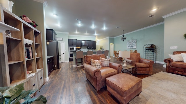 living area featuring dark wood-style flooring, visible vents, an inviting chandelier, ornamental molding, and baseboards