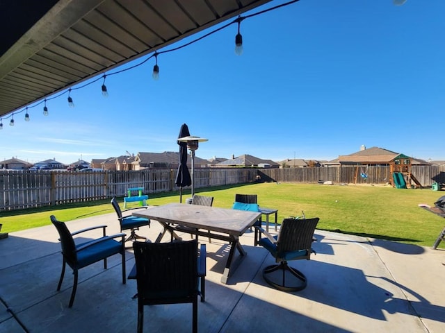 view of patio / terrace with a residential view, outdoor dining area, a playground, and a fenced backyard