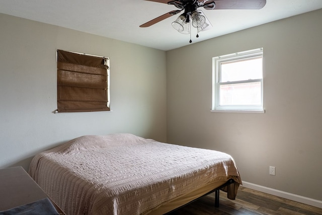 bedroom featuring a ceiling fan, baseboards, and wood finished floors