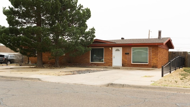 ranch-style home with brick siding and fence