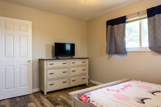 bedroom featuring baseboards and dark wood-style flooring