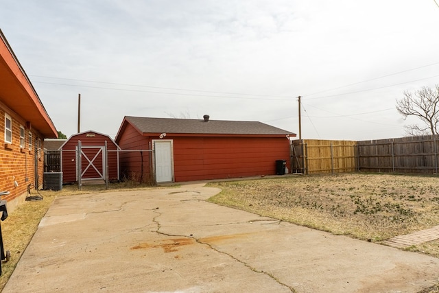 exterior space featuring an outbuilding, fence, and central air condition unit